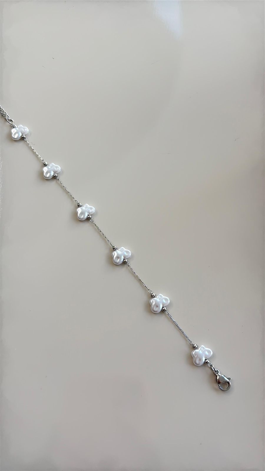 pulseira dourada com detalhe em borboleta minimalista prata
