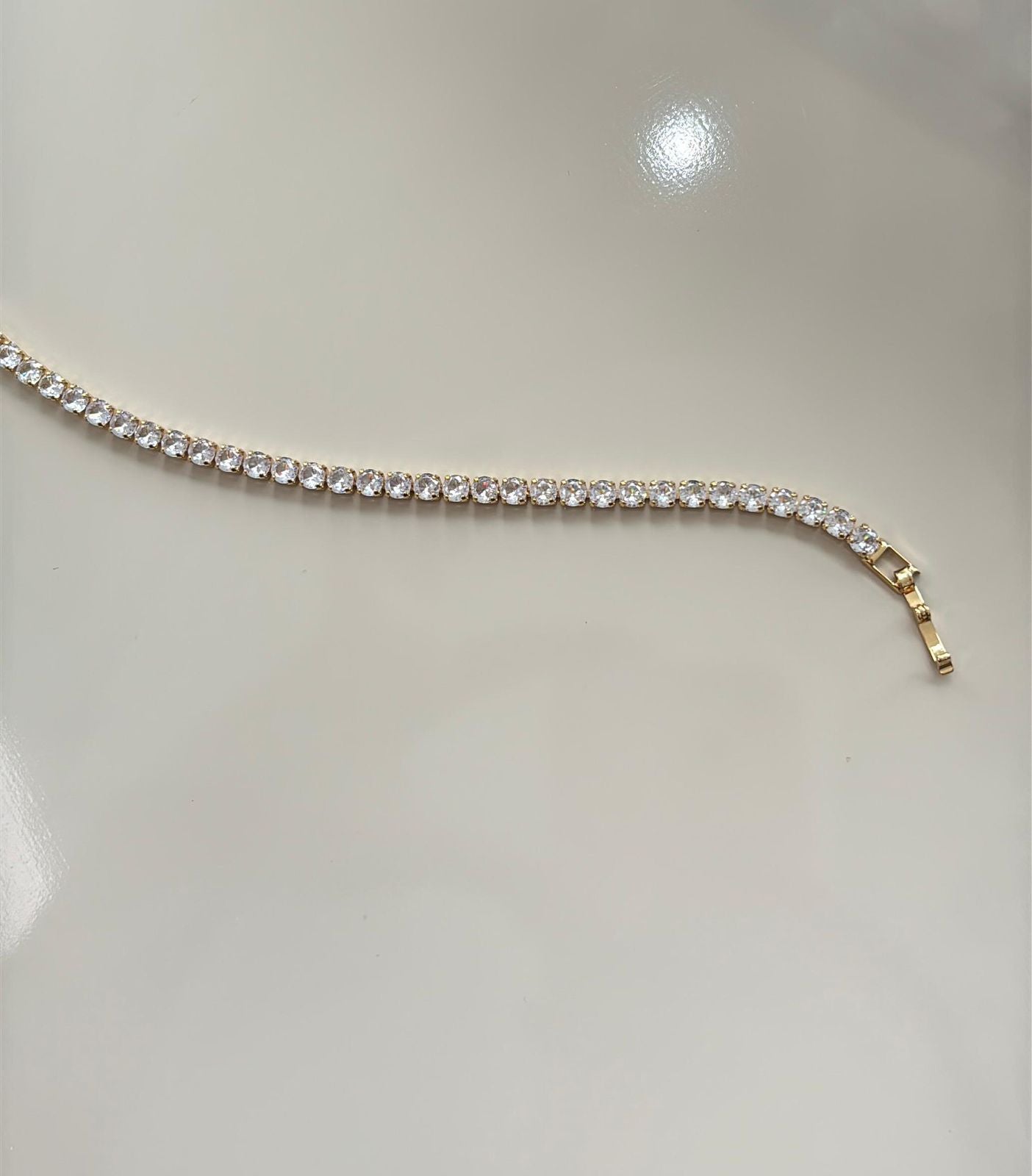 pulseira em pedras transparentes com fecho em dourado