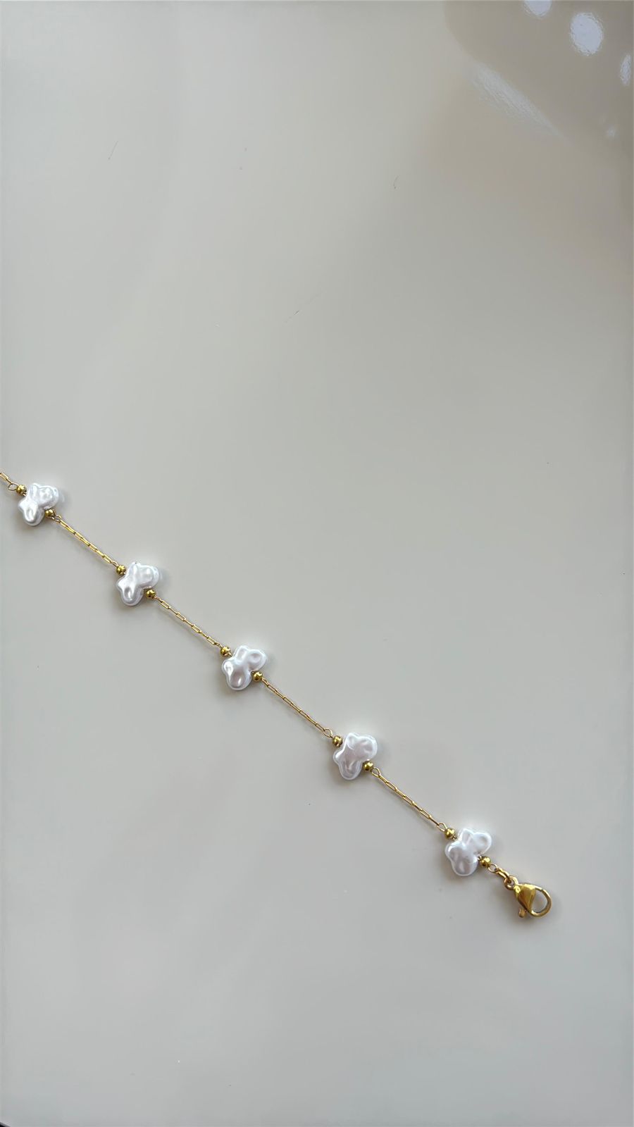 pulseira dourada com detalhe em borboleta minimalista