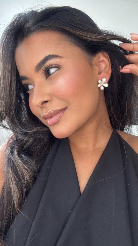 brinco dourado de flor com detalhe de pétala em pérola e cravejado