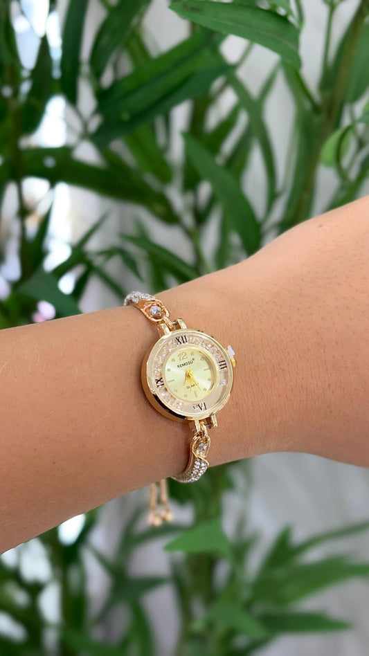 relógio minimalista com fecho de gravatinha com detalhes em cristais dourado e números romanos