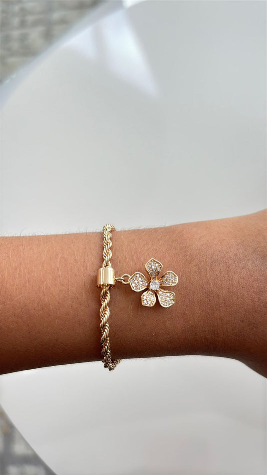 pulseira em corrente dourada com pingente de flor cravejada